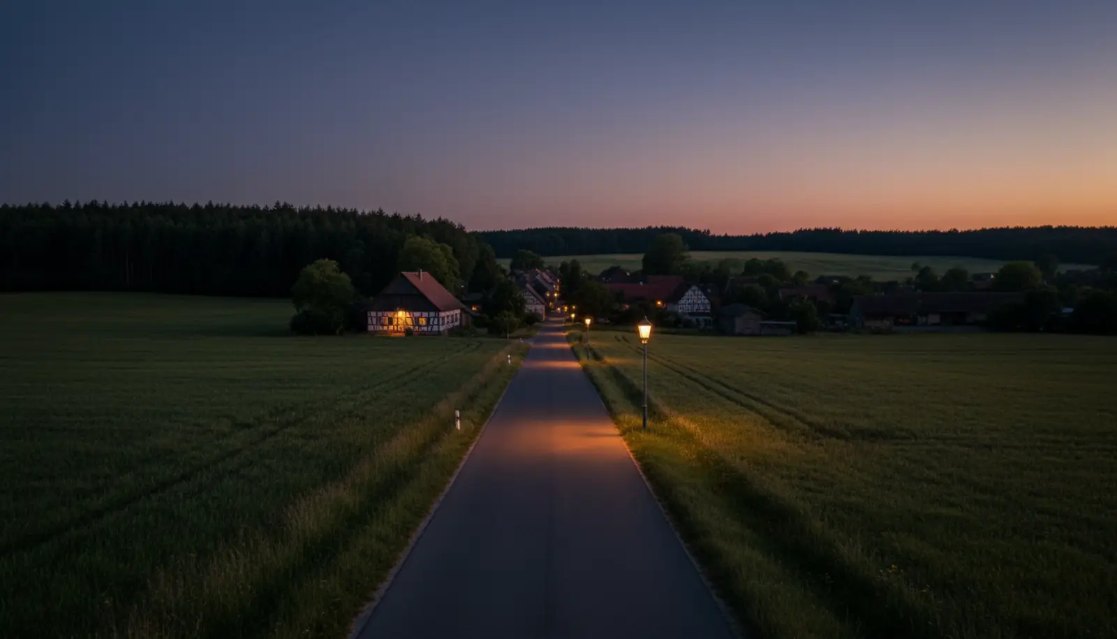 Ruhige Dorfstraße in Hünxe zwischen Feldern mit dem Waldrand des Hünxer Waldes im Hintergrund